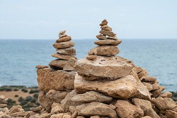 Stacked pebble stones at the beach of Paphos, Cyprus van Werner Lerooy