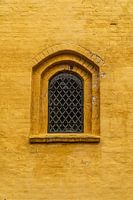 Church window in ochre wall.