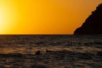 Surfers tijdens de zonsondergang in Italië van Stef Heijenk