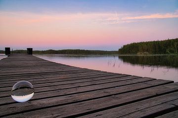 Glaskugel auf einem Steg der in einen See reicht von Martin Köbsch