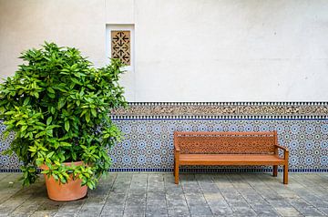 wooden bench with ornaments in front of a wall von Alexander Baumann