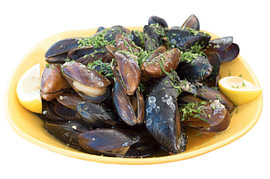 Gedämpfte Miesmuscheln mit Zitrone auf einem gelben Teller von Milcho Milev