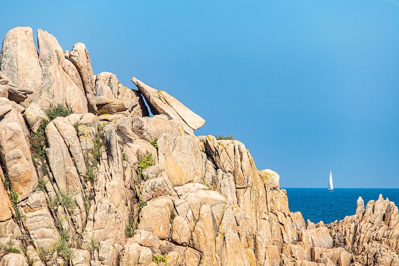 Rocks with sailboat on the coast in Brittany by Martijn Joosse