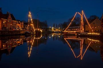 Traditionally decorated sailing ships in the town of Dokkum in Friesland Netherlands by night by Eye on You