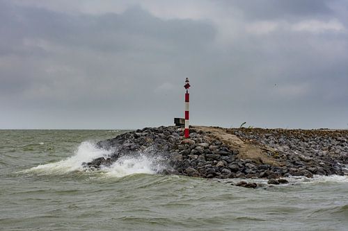 Steindamm mit Pfahl