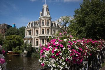 Amsterdam-Szene mit Blumen im Vordergrund auf dem Geländer einer Brücke von Gea Gaetani d'Aragona