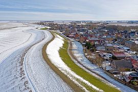 Aerial view of snow-covered village of Moddergat in Friesland on a frozen Wadden Sea in the Netherlands in winter by Eye on You