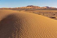 woestijnduin achtergrond op een blauwe hemel. Bergen en heuvels van gekleurd zand, Sahara Afrika. van Tjeerd Kruse thumbnail