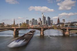Frankfurt skyline with cargo ship passing underneath Ignatz Bubis bridge, Germany by shot.by alexander