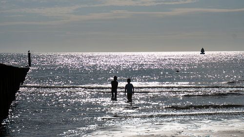 Brillanz im Meer mit Schattenbild des Kinderspielens