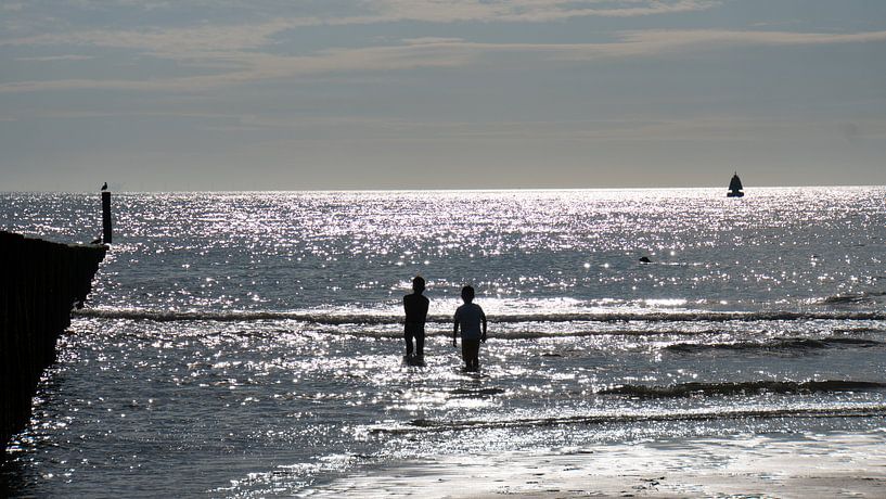 Brilliance in the sea with silhouette of children playing by Wendy Duchain