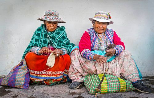 Two hands working women in traditional dress at Chivay, Peru