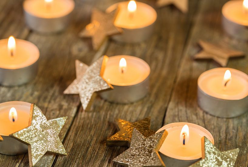 Christmas and Advent candlelights and golden star shape decoration on wood by Alex Winter