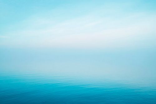 Kalm blauwe oceaan onder de hemel