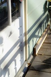 The shadow of a fence on a blue house by Artisticcreationsbyramona