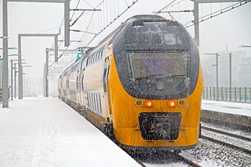 Trein komt aan op Bijlmer station in Amsterdam in een sneeuwstorm van Eye on You