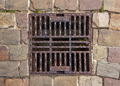 Afvoerrooster in natuurstenen bestrating