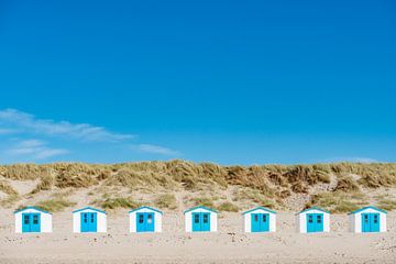 7 strandhuisjes in rij op het eiland Texel. van Ron van der Stappen