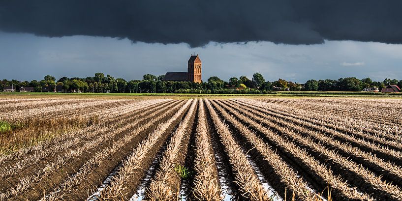Donkere lucht boven het kerkje van Ferwerd, Friesland. van Harrie Muis