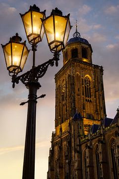 Lanterne de rue devant le Lebuinus lors d'un coucher de soleil avec des nuages à Deventer