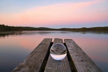 Glaskugel auf einem Steg der in einen See reicht von Martin Köbsch