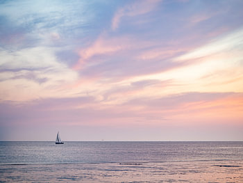 Segelboot auf See bei farbenprächtigem Sonnenuntergang in Zeeland