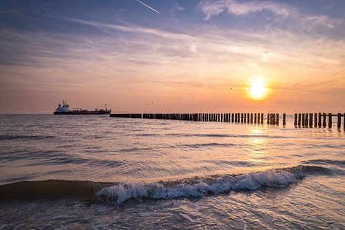 Schip passeert de kust van Westkapelle tijdens zonsondergang