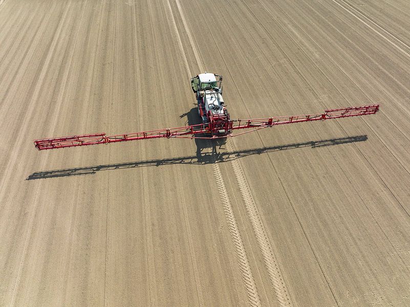 Agriculutural crops sprayer in a field seen from above by Sjoerd van der Wal Photography