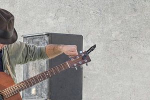 Mann stimmt Gitarre