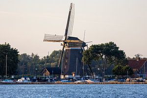 Houten windmolen aan de waterkant