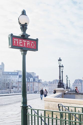 Bridge over the Seine with lanterns and metro sign in Paris