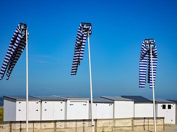Witte strandhuisjes en vlaggenmasten
