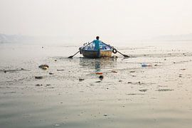 Ein Mann mit einem Holzboot rudert den heiligen Ganges River in Gosaba, Westbengalen, Indien. von Tjeerd Kruse