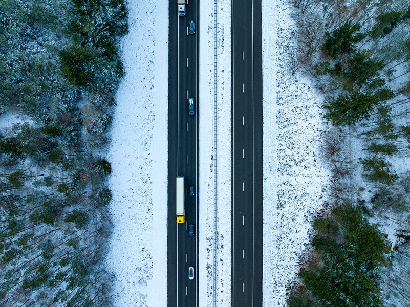 Snelweg door een besneeuwd boslandschap van bovenaf gezien van Sjoerd van der Wal Fotografie