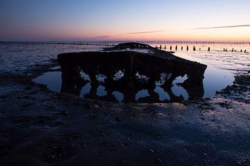 Scheepswrak bij zonsopkomst bij de Waddenzee