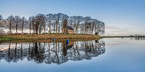 De Terp en het kerkje van Hijum, Friesland, gespiegeld in de ijsbaan