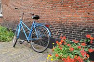 Blauwe fiets tegen muur met geraniums van Mariska van Vondelen thumbnail