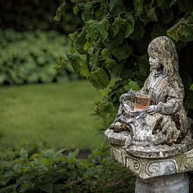 Statue de fille assise dans un jardin sur nol ploegmakers