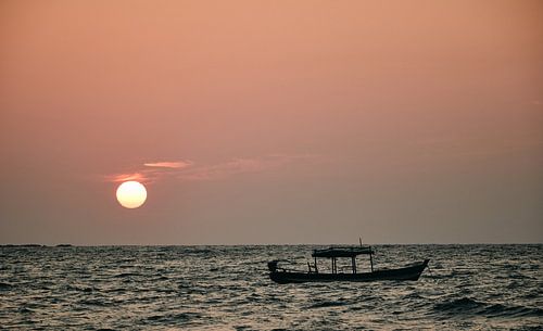 Bateau de pêche devant le soleil couchant