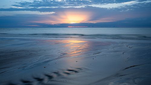 Zonsondergang, de zon piept net boven de wolken uit