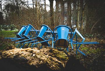 Blauwe stoelen in de regen in een industrieel landschap van Zaankanteropavontuur