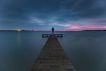 Vue des nuages sombres à l'heure bleue sur la jetée du Zuiderhaven à Den Oever