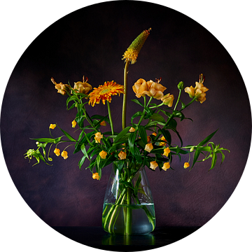 Stilleven van geel/oranje bloemen op een glazen vaas