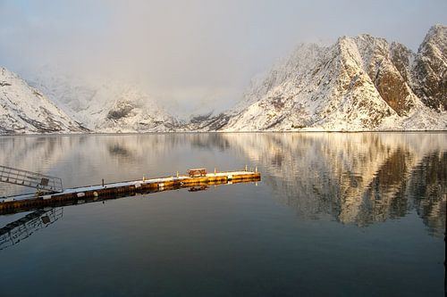 Lofoten fjord met besneeuwde bergen en reflectie