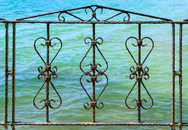 Wrought Iron Fence with Turquoise Sea Background by Milcho Milev