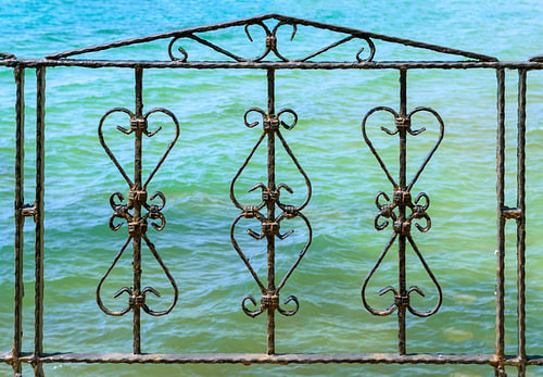 Wrought Iron Fence with Turquoise Sea Background