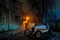 antieke modelauto Bently in stad bij avond ingemonteerd