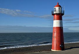 classic lighthouse on the seacoast near Westkappele, the Netherlands by Robin Verhoef