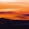 Landschaft mit Hügeln und Bäumen bei Sonnenuntergang mit einem orangefarbenen Himmel von Tanja Udelhofen