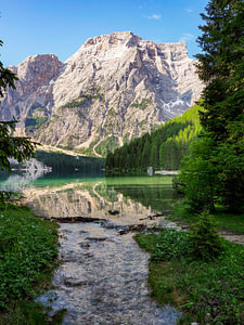 Der türkisfarbene Pragser Wildsee liegt ruhig eingebettet zwischen den steilen Felswänden der Dolomiten. Spiegelglattes Wasser